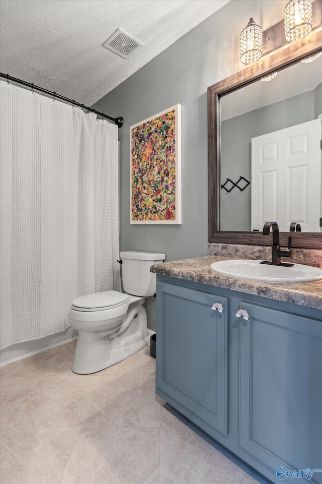 bathroom featuring vanity, curtained shower, a textured ceiling, and toilet