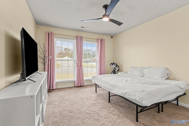 bedroom with light carpet, a textured ceiling, and ceiling fan