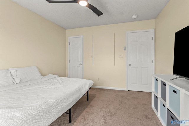 carpeted bedroom with ceiling fan and a textured ceiling