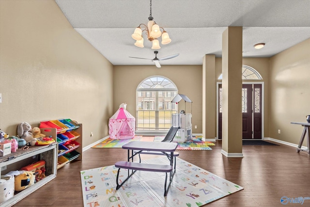 game room with a textured ceiling, dark hardwood / wood-style flooring, and ceiling fan with notable chandelier