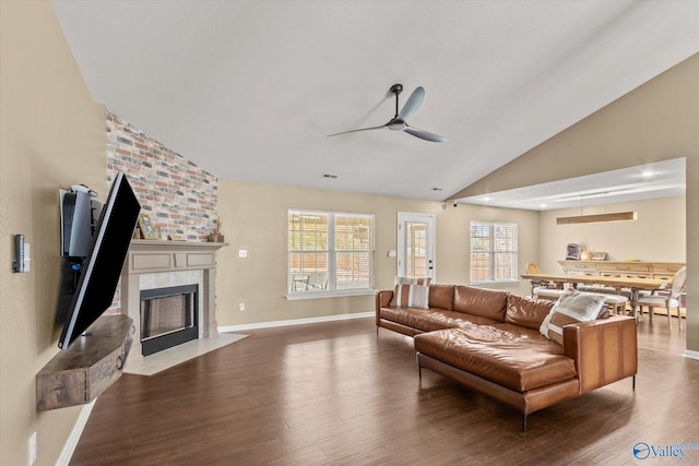 living room with lofted ceiling, a fireplace, hardwood / wood-style flooring, and ceiling fan