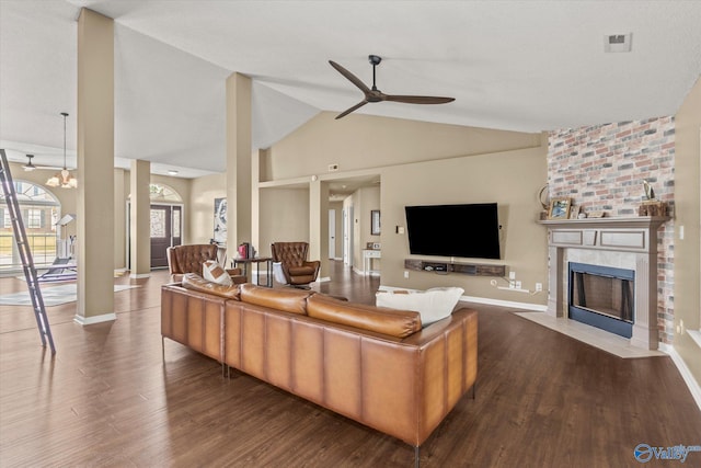 living room with high vaulted ceiling, a large fireplace, wood-type flooring, and ceiling fan with notable chandelier