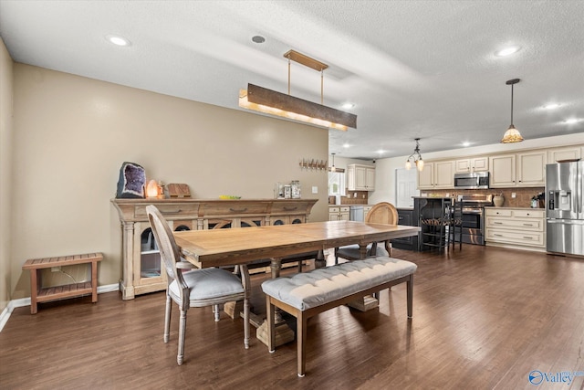 dining space featuring dark wood-type flooring and a textured ceiling