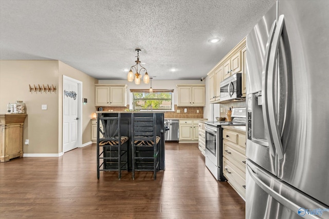 kitchen featuring stainless steel appliances, a kitchen island, and cream cabinetry