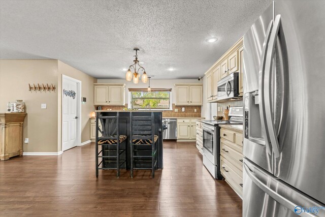 102 Bay Pointe Ln, Madison, AL 35758 - kitchen featuring stainless steel appliances, cream cabinets, a chandelier, dark wood-type flooring, and a textured ceiling