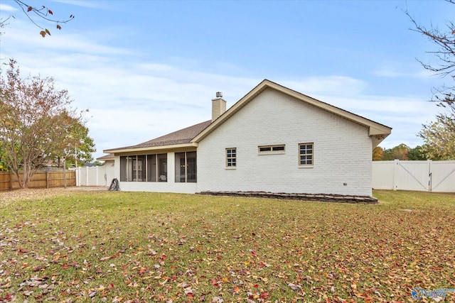 back of property with a sunroom and a lawn