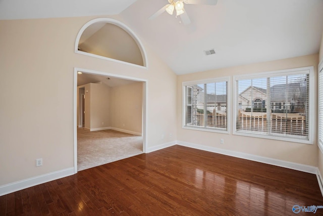 empty room with hardwood / wood-style flooring, ceiling fan, and high vaulted ceiling