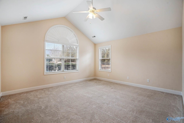 carpeted spare room with ceiling fan and vaulted ceiling