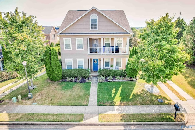 view of front of house with a front yard and a balcony