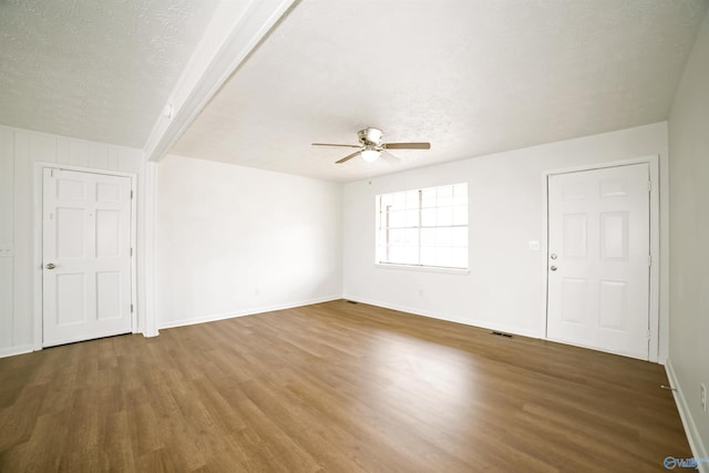 spare room with baseboards, a textured ceiling, wood finished floors, and a ceiling fan