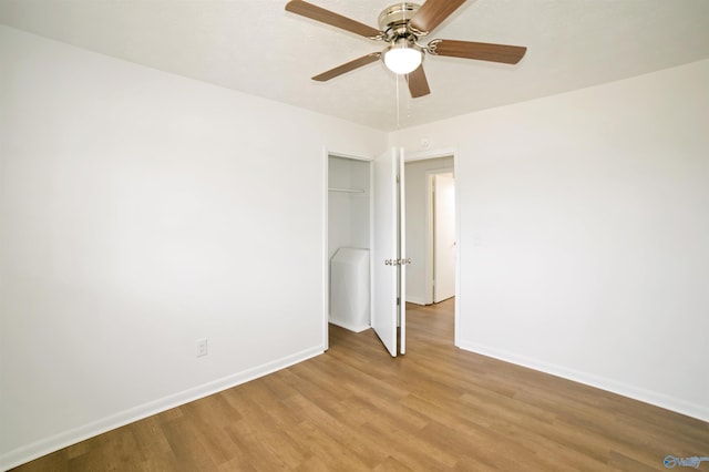 spare room with light wood-style flooring, a ceiling fan, and baseboards