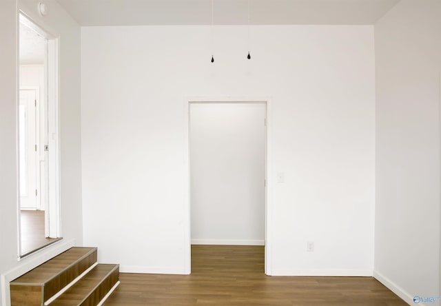 unfurnished room with baseboards and wood finished floors