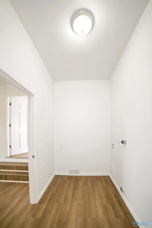 spare room featuring visible vents, baseboards, and wood finished floors