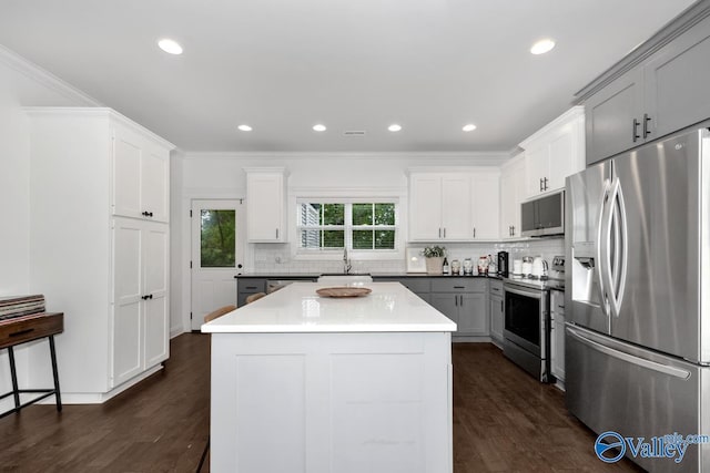 kitchen with a kitchen island, appliances with stainless steel finishes, dark hardwood / wood-style floors, sink, and gray cabinetry