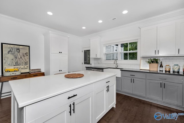 kitchen featuring white cabinetry, crown molding, sink, and gray cabinetry