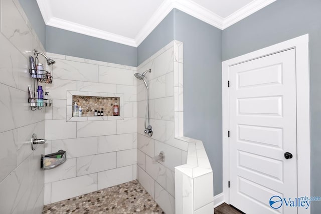 bathroom with ornamental molding and a tile shower