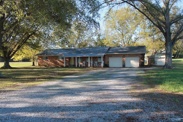 view of front of home featuring driveway, brick siding, an attached garage, and a front yard