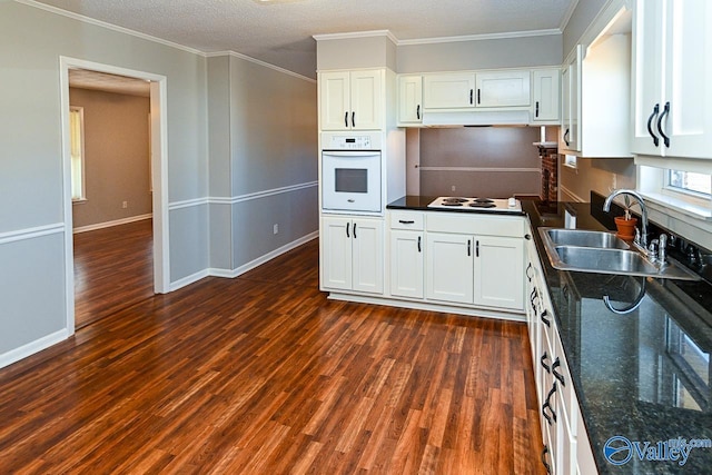 7853 Danville Rd, Danville, AL 35619 - kitchen with white appliances, a sink, white cabinets, dark wood finished floors, and ornamental molding