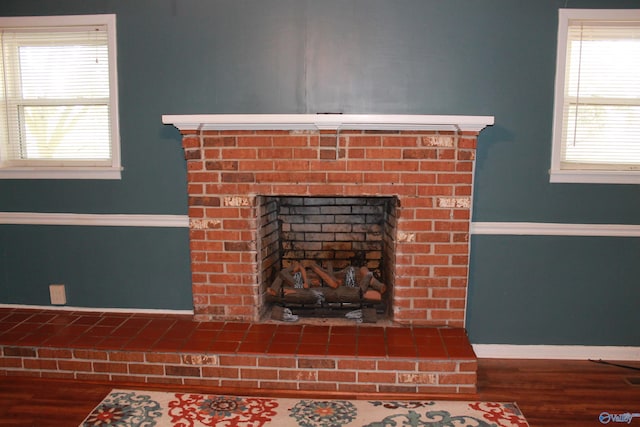 details featuring a fireplace, wood finished floors, and baseboards