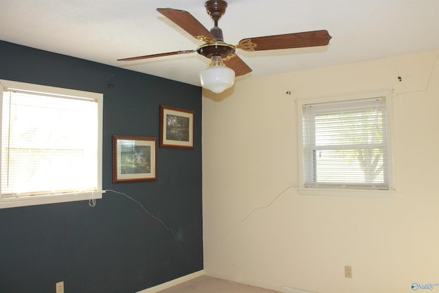 empty room featuring ceiling fan and baseboards