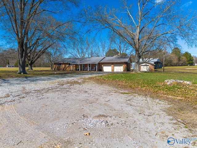 view of front of home featuring driveway, a front lawn, and an attached garage