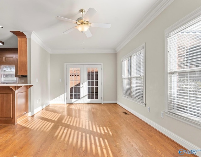 unfurnished living room featuring light wood-type flooring, a wealth of natural light, and french doors