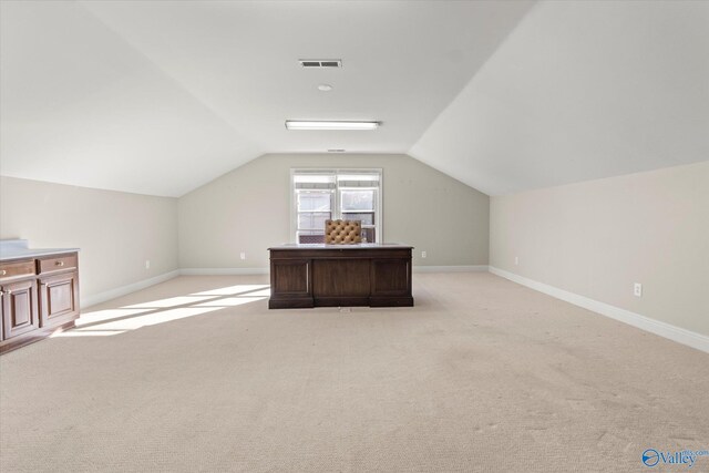 additional living space with light colored carpet and vaulted ceiling