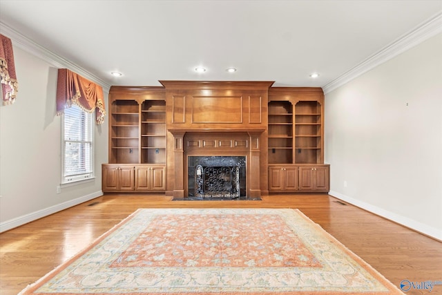 unfurnished living room with light hardwood / wood-style floors, ornamental molding, and a high end fireplace