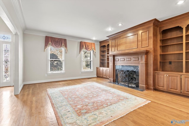 unfurnished living room featuring light hardwood / wood-style floors, a premium fireplace, and crown molding