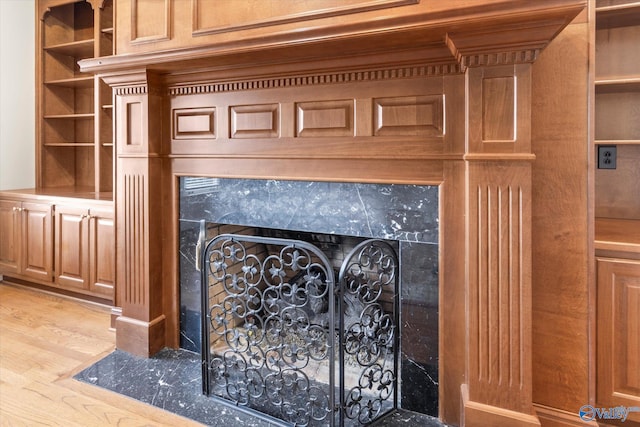 interior details with hardwood / wood-style flooring and a high end fireplace