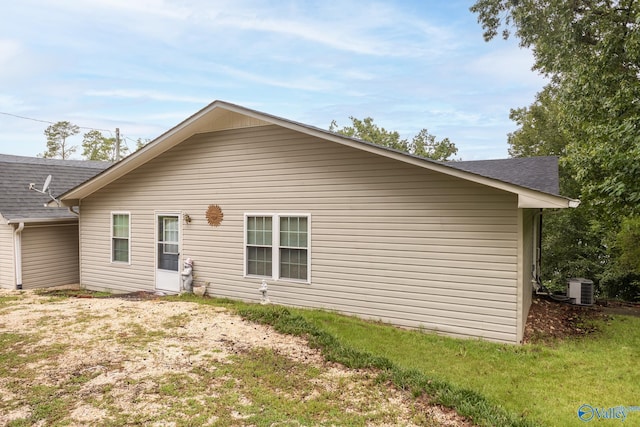 back of property with a shingled roof and cooling unit