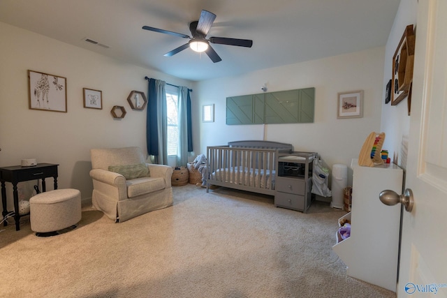carpeted bedroom with a nursery area, visible vents, and ceiling fan