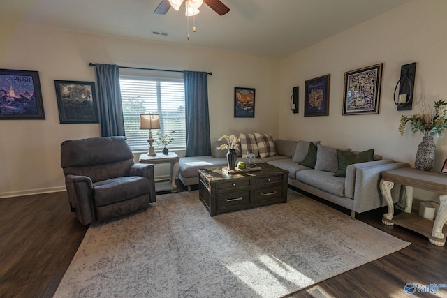 living area featuring visible vents, baseboards, a ceiling fan, and wood finished floors