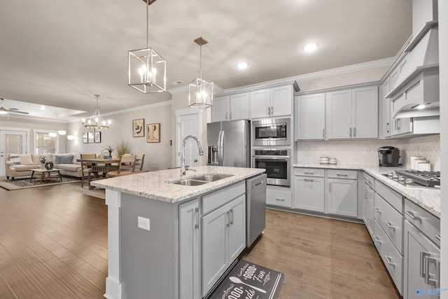 kitchen featuring sink, stainless steel appliances, pendant lighting, dark wood-type flooring, and a kitchen island with sink