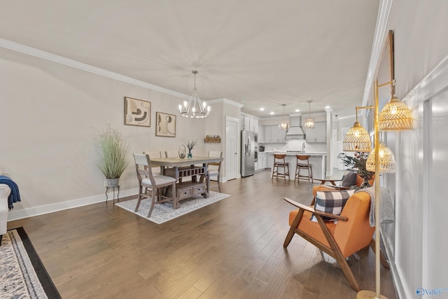 dining room featuring sink, dark wood-type flooring, and crown molding