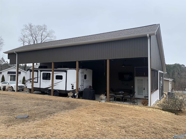 view of outdoor structure featuring a carport and a lawn