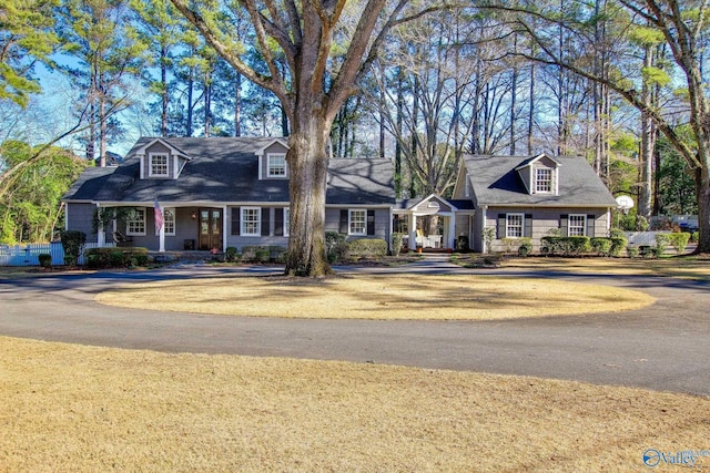 cape cod house featuring covered porch