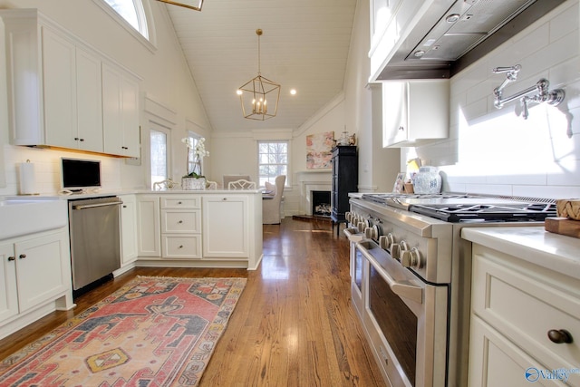 kitchen featuring a chandelier, light wood-type flooring, pendant lighting, stainless steel appliances, and white cabinets