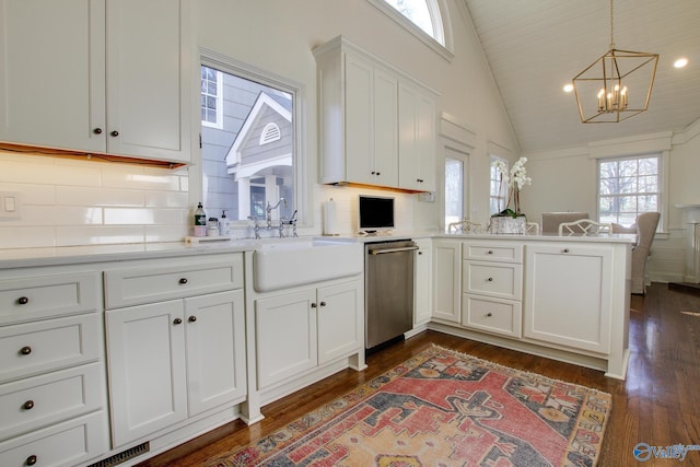 kitchen with sink, kitchen peninsula, dishwasher, pendant lighting, and white cabinets