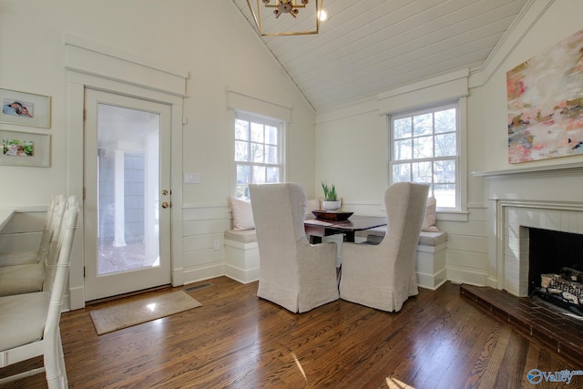 unfurnished dining area featuring a brick fireplace, dark wood-type flooring, and vaulted ceiling