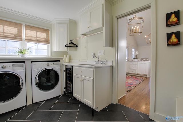 laundry room with sink, washing machine and dryer, cabinets, dark tile patterned flooring, and beverage cooler