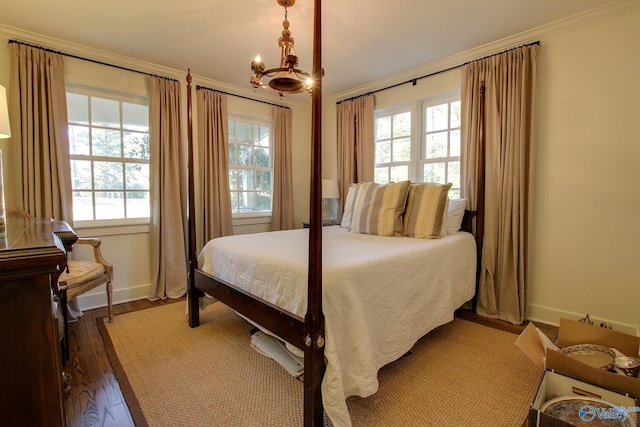 bedroom featuring crown molding, dark hardwood / wood-style flooring, and an inviting chandelier