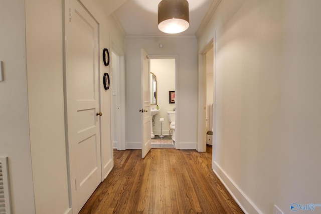 corridor with hardwood / wood-style flooring and crown molding