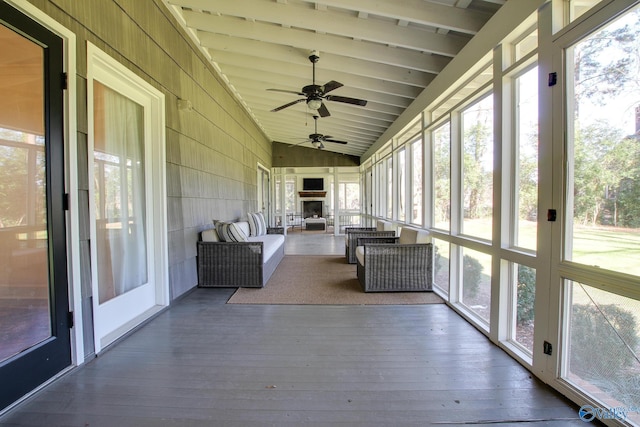 unfurnished sunroom featuring lofted ceiling with beams and a wealth of natural light