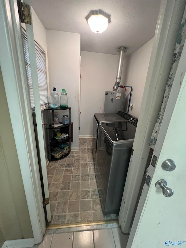 laundry room with separate washer and dryer, a textured ceiling, and water heater