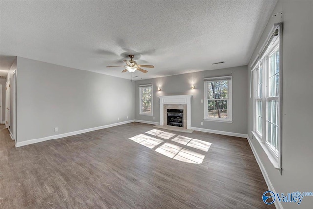 unfurnished living room with a textured ceiling, ceiling fan, and dark wood-type flooring