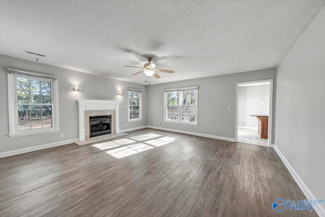 unfurnished living room with plenty of natural light, dark hardwood / wood-style flooring, and a textured ceiling