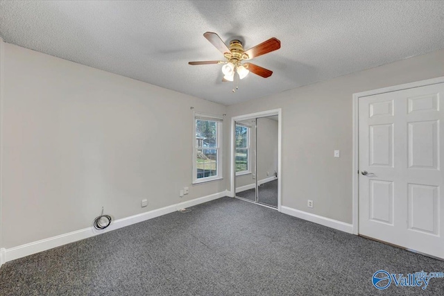 unfurnished bedroom with ceiling fan, a closet, dark carpet, and a textured ceiling