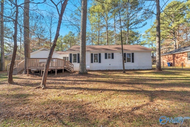 rear view of property with a yard and a deck