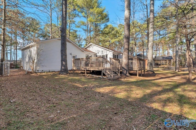 rear view of property featuring a yard and a deck